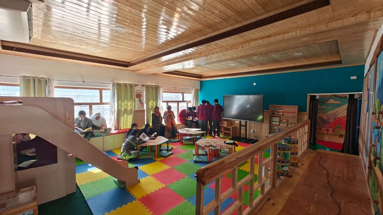 The Balvatika model classroom with a colourful interlocking-mat floor, low wooden furniture and children reading