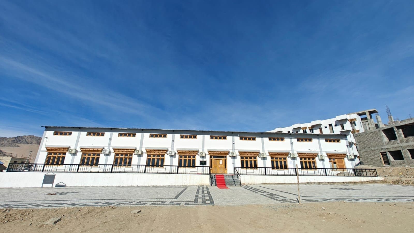 The Exhibition Hall, a renovated two-storey building with wooden-framed windows and a paved courtyard