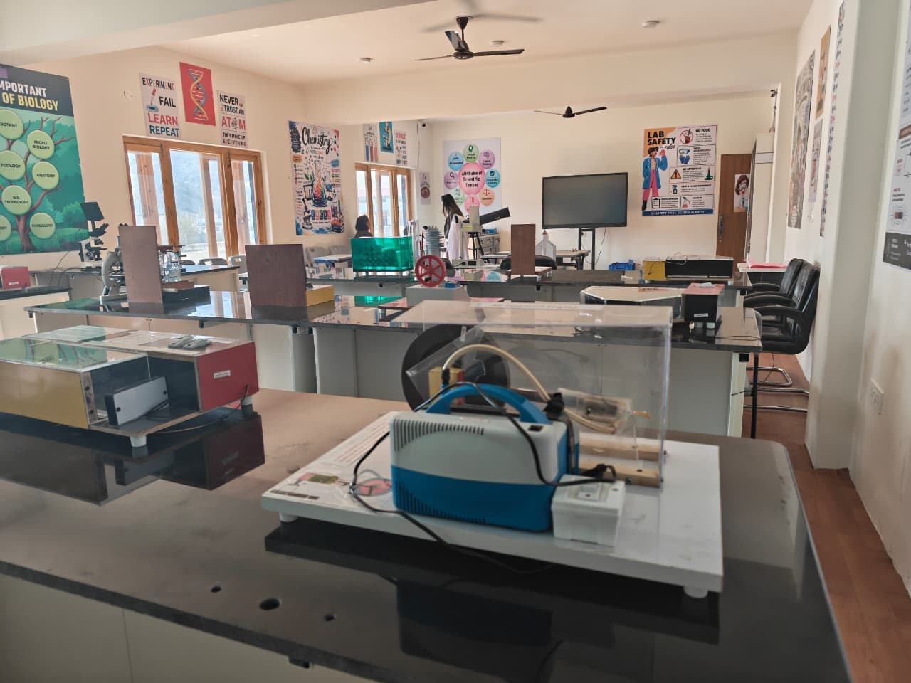 Science apparatus and demonstration models on lab benches, with microscopes and posters on the walls