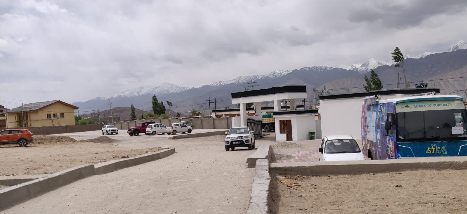Mobile STEM Bus parked at the DIET Leh campus with mountains behind